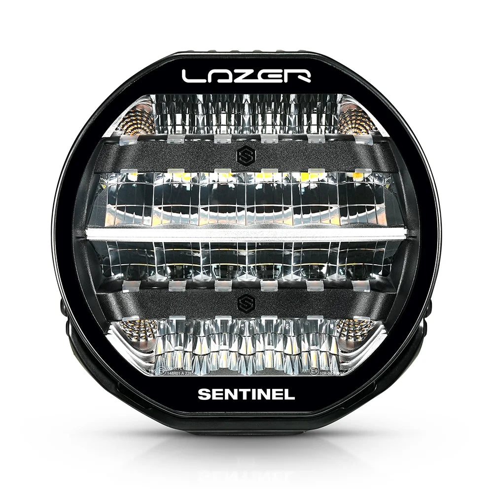 Musta 9-tuumainen Lazer Sentinel Highline -lisävalo, jossa on pyöreä muotoilu, heijastimet useassa rivissä ja jäähdytysrivat taustalla. Valo on valkoista taustaa vasten ja kuvattu edestä.