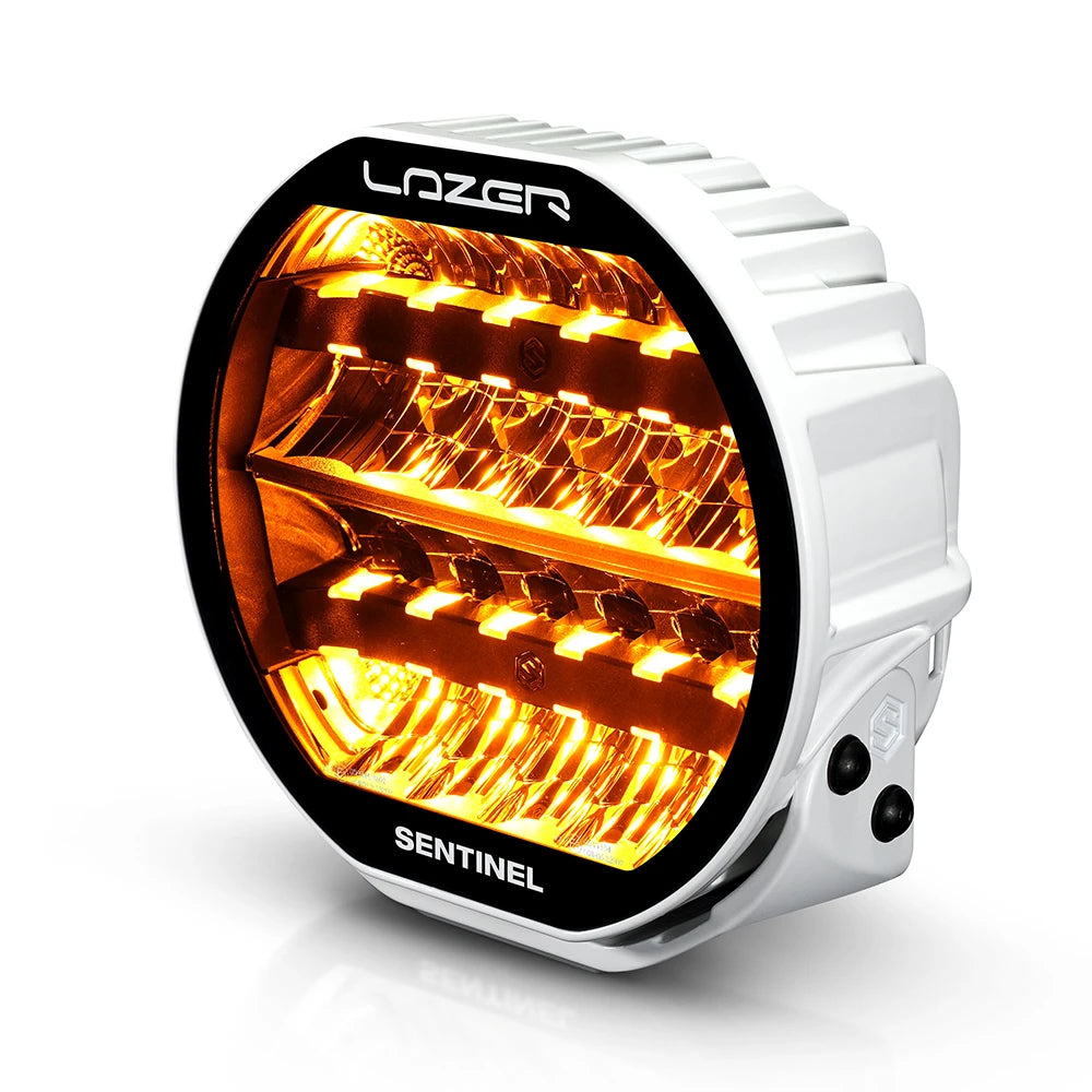 Valkoinen Lazerlamps Sentnel 9" Highline kaukovalo kuvattu etuviistosta ylhäältä oranssilla parkilla