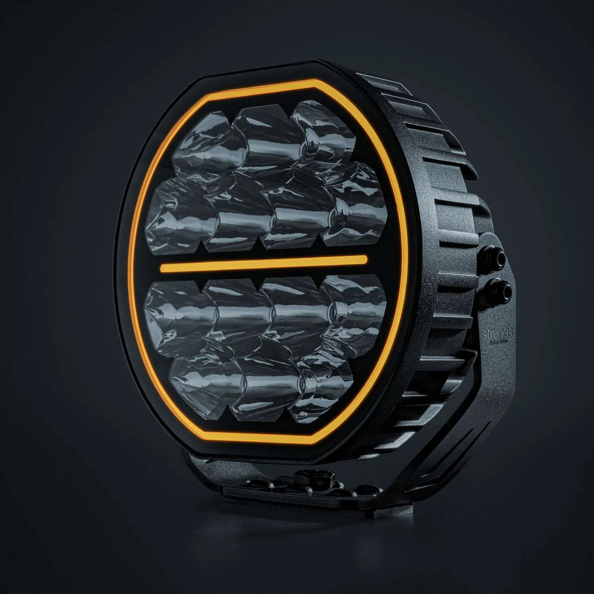 Strands Big Energy 7" pyöreä lisävalo missä tasainen ylä- ja alaosa. Oranssi parkkivalo kiertää valon sisäreunaa, sekä keskellä oranssi parkkiviiva. Valo kuvattu mustaa taustaa vasten.