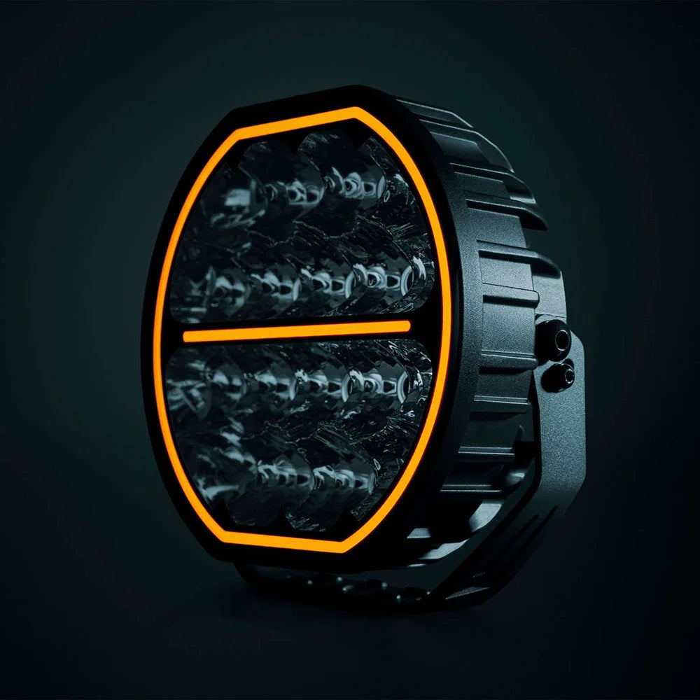 Strands Big Energy 9" pyöreä led lisävalo missä tasainen ylä- ja alaosa. Oranssi parkki kiertää valon ulkoreunaa, sekä keskellä oranssi parkkiviiva. Valo mustaa taustaa vasten.