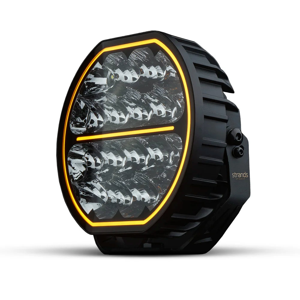 Strands Big Energy 9" pyöreä led lisävalo missä tasainen ylä- ja alaosa. Oranssi parkki kiertää valon ulkoreunaa, sekä keskellä oranssi parkkiviiva. Valo valkoista taustaa vasten.