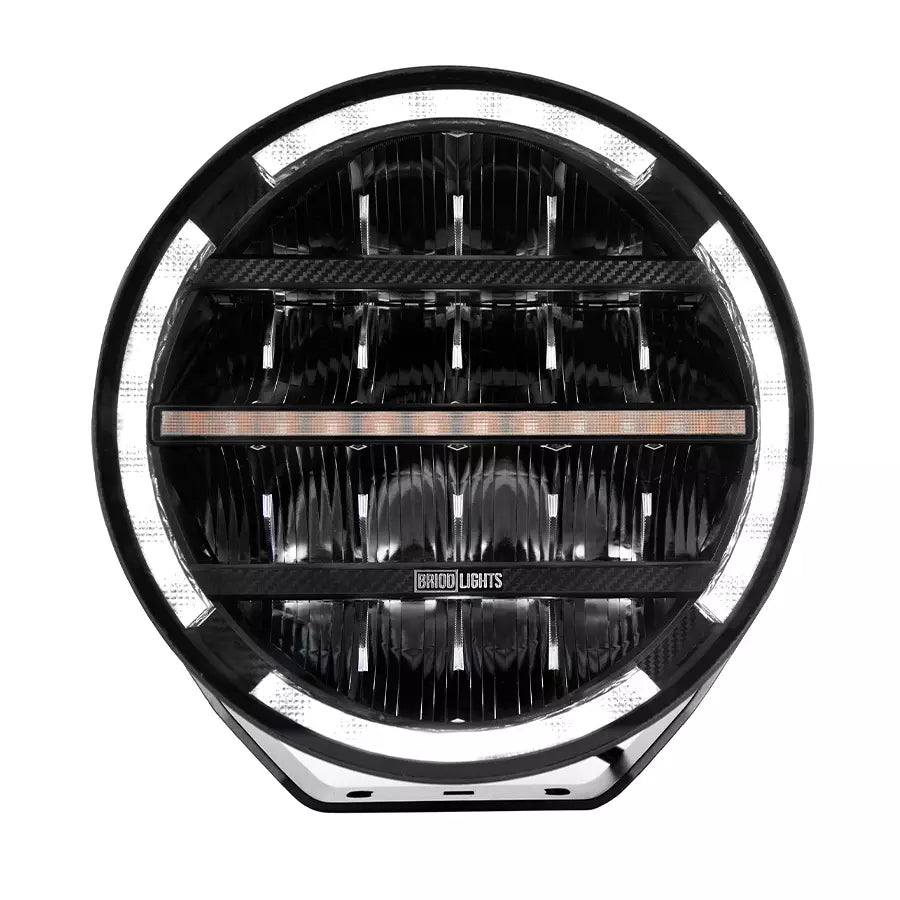 BriodLights Olympus 9-tuumainen pyöreänmuotoinen lisävalo mustassa värissä. Valossa heijastimet neljässä rivissä ja reunoja mukailevat parkkivalot valkoisella ledillä. Kuvattu edestä ja valkoista taustaa vasten.