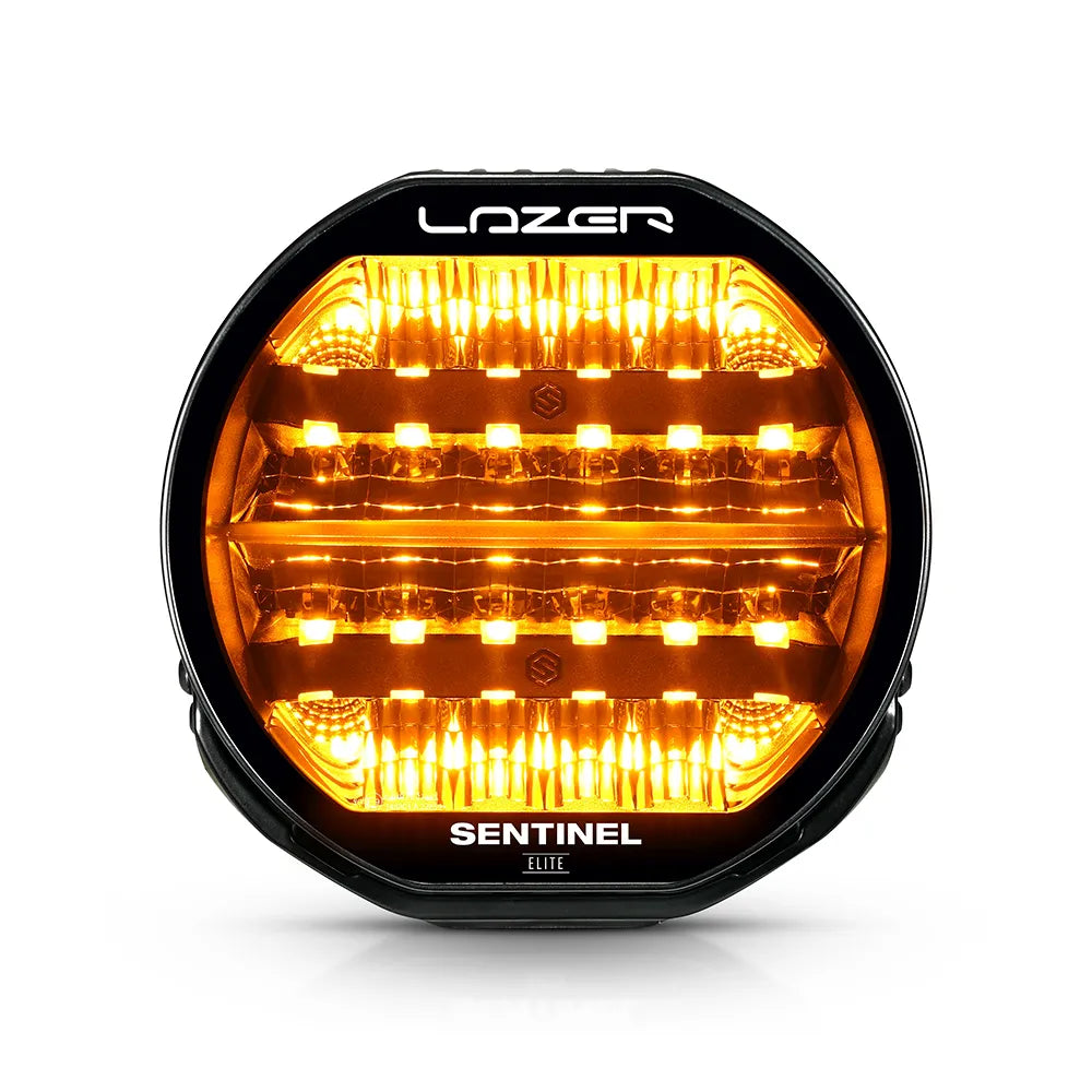 Musta Lazer Sentinel Elite 9-tuumainen lisävalo, jossa on pyöreä muotoilu, oranssit LED-parkkivalot, heijastimet useassa rivissä ja jäähdytysrivat taustalla. Valo on valkoista taustaa vasten ja kuvattu edestä.
