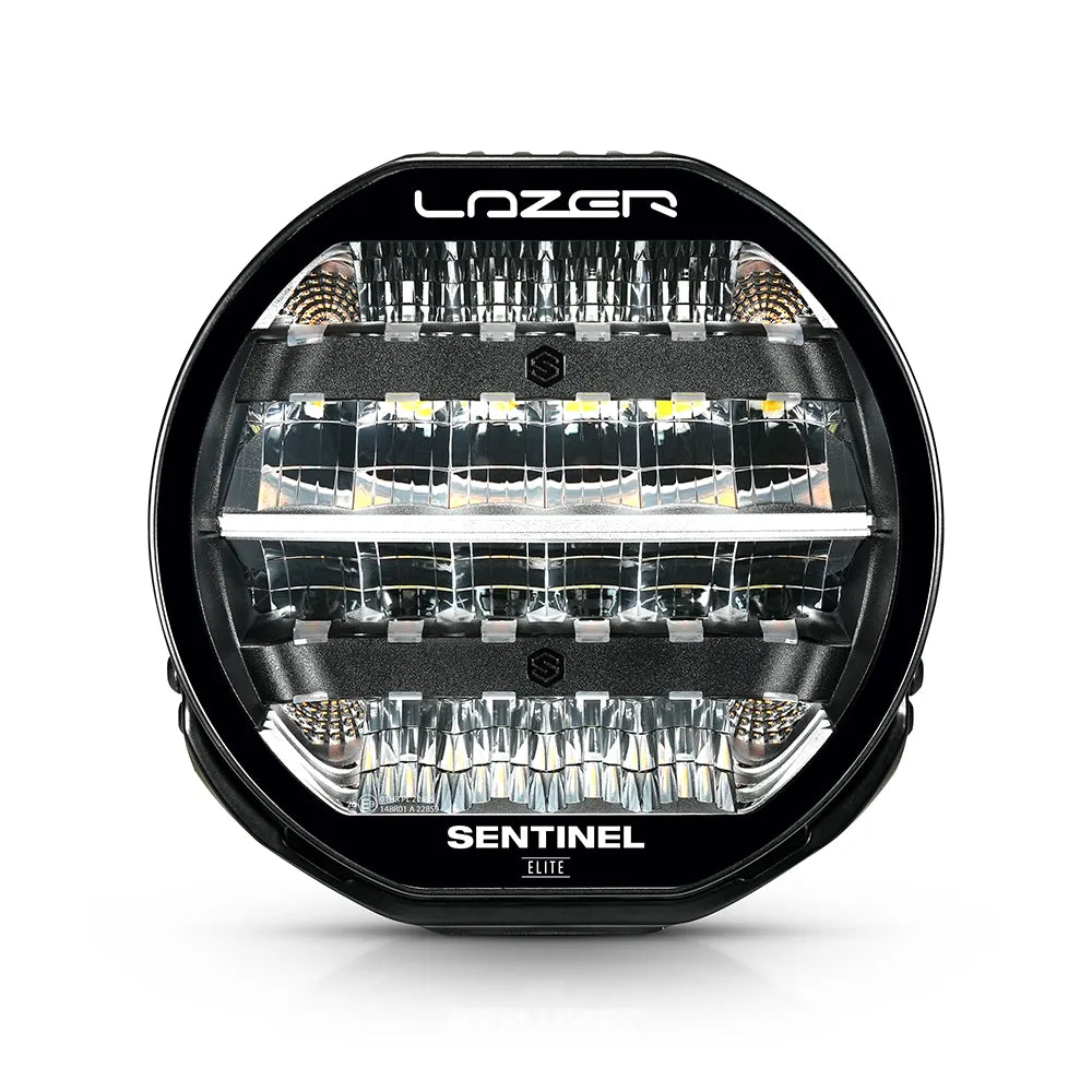Musta Lazer Sentinel Elite 9-tuumainen lisävalo, jossa on pyöreä muotoilu, heijastimet useassa rivissä ja jäähdytysrivat taustalla. Valo on valkoista taustaa vasten ja kuvattu edestä.